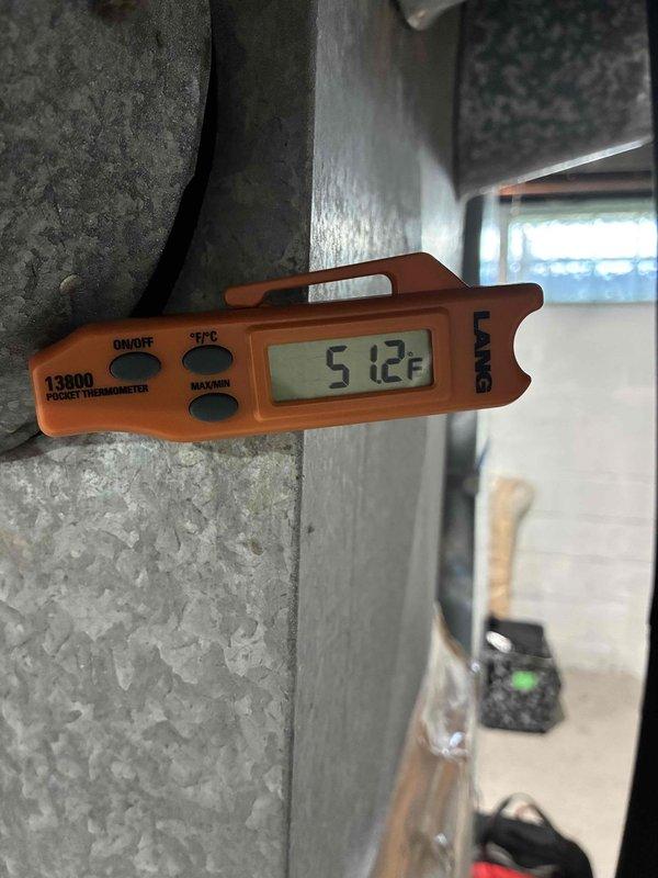 Performed routine tune-up maintenance on outdoor Ameristar condenser unit approximately 6 years old. Completed standard inspection procedures, verified operational temperatures with digital thermometer showing 51.2°F at measurement point, and documented equipment condition through photographs. Unit found in satisfactory operating condition with normal airflow through cabinet vents and fan assembly functioning properly.