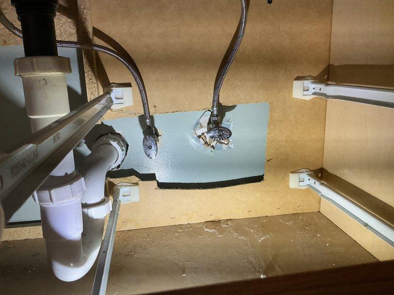 Responded to service call for cold water valve issue under bathroom vanity. Upon inspection, found existing supply line configuration required attention beneath vanity cabinet during active renovation phase. Assessed flexible braided supply line connections and mounting hardware attached to backing plate. Replaced faulty cold water valve assembly and verified proper installation of supply lines to ensure leak-free operation. Tested water flow and pressure after valve replacement to confirm system functionality. All plumbing connections secured and operational for continued bathroom renovation work.
