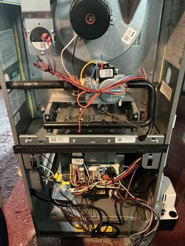 Responded to service call for 3-year-old Lennox WT 12-2032 central air conditioning system on second floor with reported blower fan failure and frozen refrigerant line at outdoor condenser unit. Upon arrival, accessed furnace cabinet and inspected blower motor assembly, electrical connections, and gas valve wiring for proper operation. Confirmed blower motor functionality and verified all electrical connections were secure with no signs of overheating or component failure. Proceeded to outdoor unit and identified frozen suction line on Lennox condenser, indicating restricted airflow or low refrigerant charge. Inspected both outdoor units positioned on concrete pads against structure, noting condenser coil condition and proper clearances. Determined frozen line was caused by restricted airflow due to dirty evaporator coil inside air handler. Powered down system to allow ice buildup to thaw completely. Removed and cleaned evaporator coil, removing dust and debris accumulation that was bl