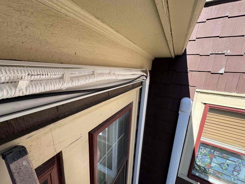 Returned to site to properly rehang mini-split head unit that required repositioning. Corrected condensate drain line routing and secured refrigerant line set with appropriate line hide covering for improved aesthetics and protection. Utilized ladder to access elevated installation point on building exterior. Verified proper drainage function and ensured all refrigerant lines were adequately concealed and secured to exterior wall per manufacturer specifications. System tested and confirmed operational upon completion of warranty corrections.