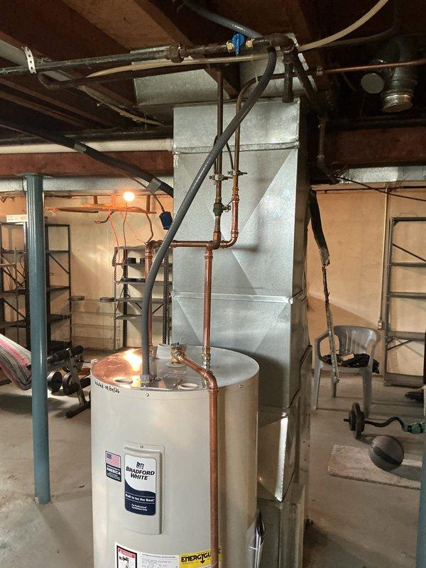 Removed existing 40-gallon gas water heater and installed new 40-gallon electric water heater in basement location. Installed 240-volt electrical circuit to power unit, capped 3-inch flue penetration at chimney, and capped gas supply line at previous connection point. Repositioned water heater orientation to face rear of residence and connected copper supply piping with shutoff valves. Unit tested and verified operational upon completion.