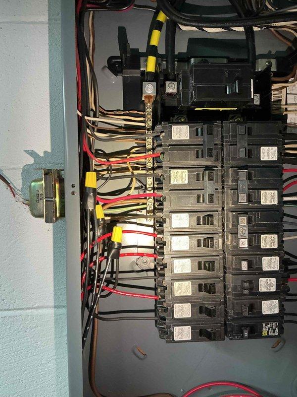Conducted electrical estimate for backup generator installation at residential property. Assessed existing electrical panel configuration and available space in basement area for generator transfer switch installation. Documented current electrical service setup, including circuit breaker arrangement and panel capacity, to determine compatibility with proposed generator system. Photographed installation location showing basement storage area with exposed ceiling joists and HVAC ductwork to identify optimal routing for electrical conduit and transfer switch placement. Evaluated clearance requirements and accessibility for future generator connection and maintenance access.