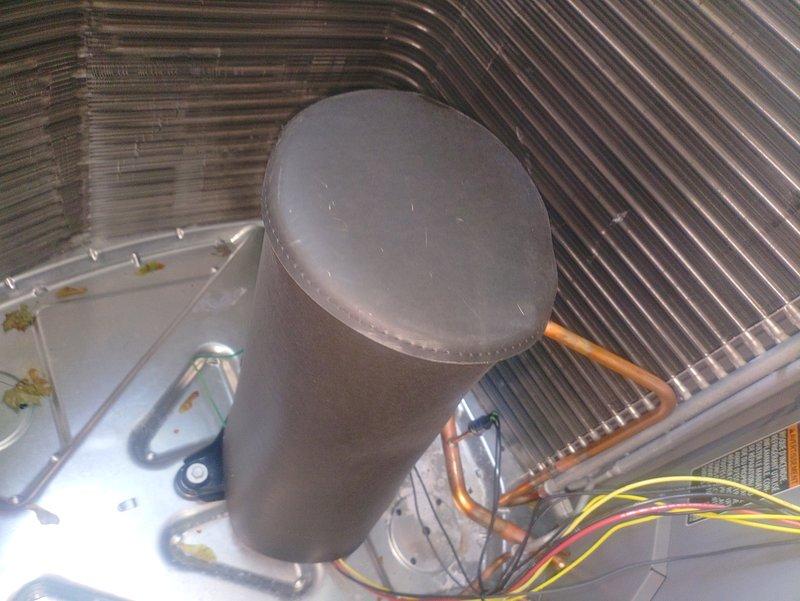 Responded to post-installation inspection concern regarding foreign object inside outdoor condensing unit. Upon arrival, accessed unit interior and identified rubber shipping sleeve that had been inadvertently left in place during initial installation. Removed shipping material from compressor area, verified all refrigerant lines, electrical connections, and internal components were properly secured and free of obstructions. Unit inspected and confirmed ready for final inspection approval.