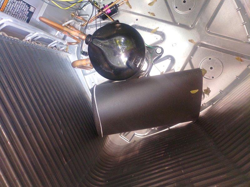 Responded to post-installation inspection concern regarding foreign object inside outdoor condensing unit. Upon arrival, accessed unit interior and identified rubber shipping sleeve that had been inadvertently left in place during initial installation. Removed shipping material from compressor area, verified all refrigerant lines, electrical connections, and internal components were properly secured and free of obstructions. Unit inspected and confirmed ready for final inspection approval.