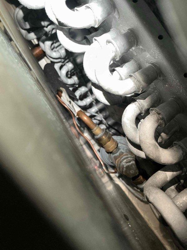 Completed scheduled maintenance visit on 10-year-old air conditioning system. Upon inspection, discovered significant frost and ice accumulation on evaporator coil copper piping, indicating restricted airflow or low refrigerant charge. Inspected blower assembly and found dust buildup on squirrel cage fan blades affecting system performance. Cleaned blower wheel components and verified motor operation. Addressed airflow restriction issues contributing to coil icing condition. System operational upon completion of maintenance procedures.