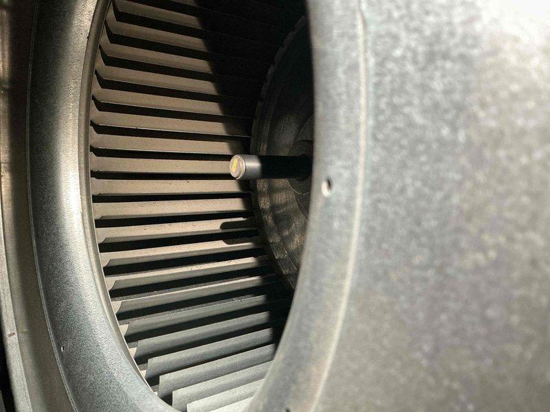 Completed scheduled maintenance visit on 10-year-old air conditioning system. Upon inspection, discovered significant frost and ice accumulation on evaporator coil copper piping, indicating restricted airflow or low refrigerant charge. Inspected blower assembly and found dust buildup on squirrel cage fan blades affecting system performance. Cleaned blower wheel components and verified motor operation. Addressed airflow restriction issues contributing to coil icing condition. System operational upon completion of maintenance procedures.