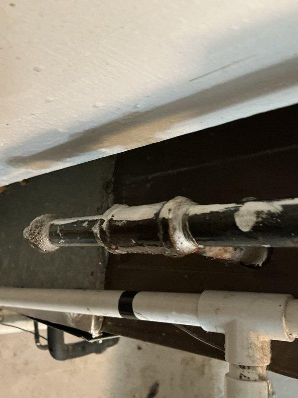 Responded to gas line repair call at 74-year-old residential property. Upon inspection, identified severely corroded metallic gas pipe in basement area with significant rust deterioration at joints and along vertical run. Assessed structural mounting and proximity to existing PVC plumbing lines. Completed necessary repairs to restore safe gas line operation, ensuring all connections met current code requirements. No additional parts required for completion. Documented existing conditions and completed repairs with photographic evidence showing pre-repair corrosion and workspace configuration in basement and garage storage areas.