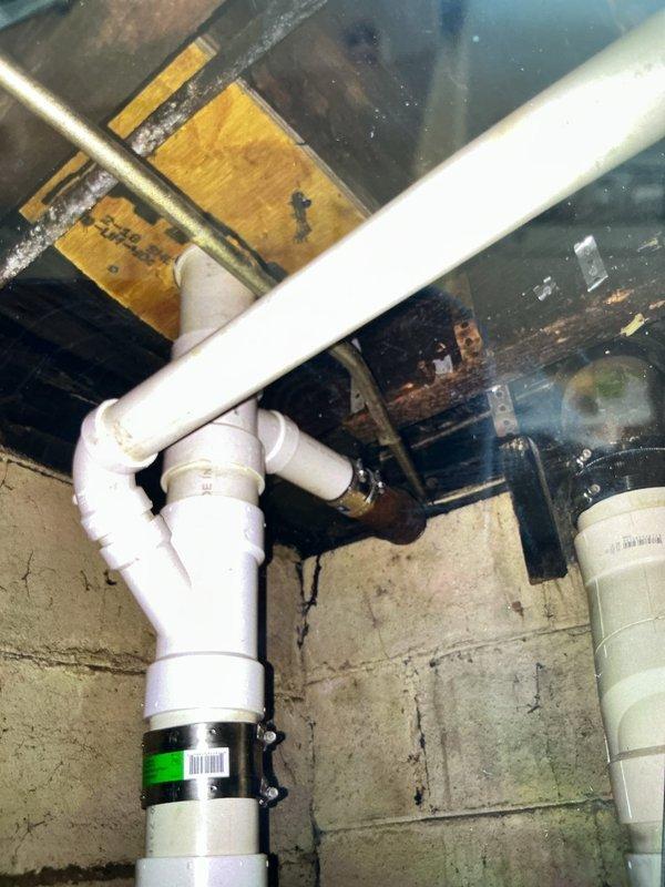Completed full replacement of first floor bathroom group drain line system over a two-day period. Removed existing deteriorated drainage piping and installed new PVC drain lines to all fixtures, including a new closet flange for the toilet. Work involved removing and reinstalling the toilet, running new branch lines to each fixture, and ensuring proper venting and drainage slope throughout the system. All connections were properly fitted and secured with appropriate brackets and supports to structural members in the basement area. System was tested for proper flow and verified leak-free operation upon completion.