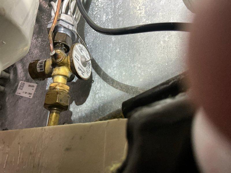 Responded to service call for insufficient cooling with indoor temperature reading 75°F when thermostat set to 72°F. Performed diagnostic testing on one-year-old air conditioning system using manifold gauges and digital measurement equipment. Found refrigerant charge at 23.6 PSI, indicating system was operating below optimal levels. Inspected outdoor condensing unit connections, indoor evaporator coil components, and refrigerant line set for leaks or restrictions. Added refrigerant to manufacturer specifications, verified proper system pressures and temperatures, and confirmed adequate cooling performance before departure.