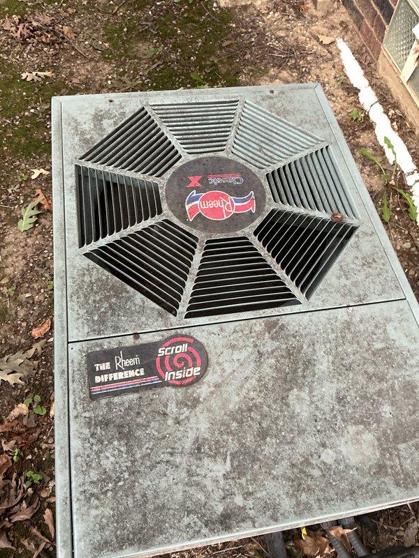 Performed routine maintenance visit on 30+ year old Rheem scroll compressor outdoor condensing unit for MVP customer. Unit is positioned in narrow side yard area between brick foundation and privacy fence with electrical disconnect properly mounted on exterior wall. System operational at time of inspection, though age of equipment noted for future replacement consideration.