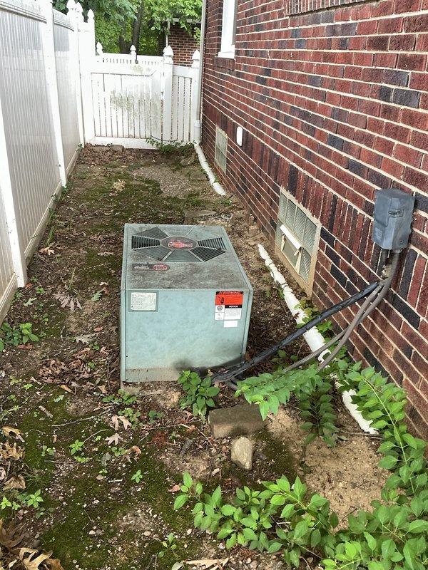 Performed routine maintenance visit on 30+ year old Rheem scroll compressor outdoor condensing unit for MVP customer. Unit is positioned in narrow side yard area between brick foundation and privacy fence with electrical disconnect properly mounted on exterior wall. System operational at time of inspection, though age of equipment noted for future replacement consideration.