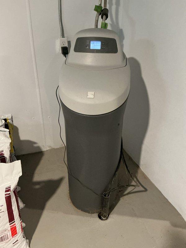 Conducted on-site assessment for water filtration system installation at residential property. Evaluated existing water softener unit with digital control panel and pressure tank system, documented current plumbing configuration including copper supply lines and valve connections, and photographed utility room layout to provide comprehensive estimate for upgraded water treatment solutions.
