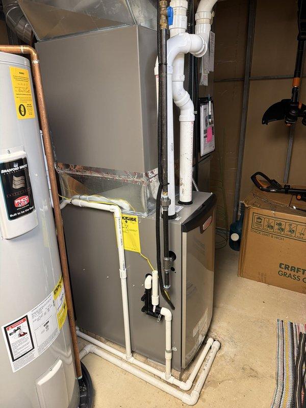 Completed installation of high-efficiency 97% AFUE Lennox furnace system in basement utility area. Unit installed with proper white PVC intake and exhaust venting routed through ceiling, all connections secured and tested for proper operation.