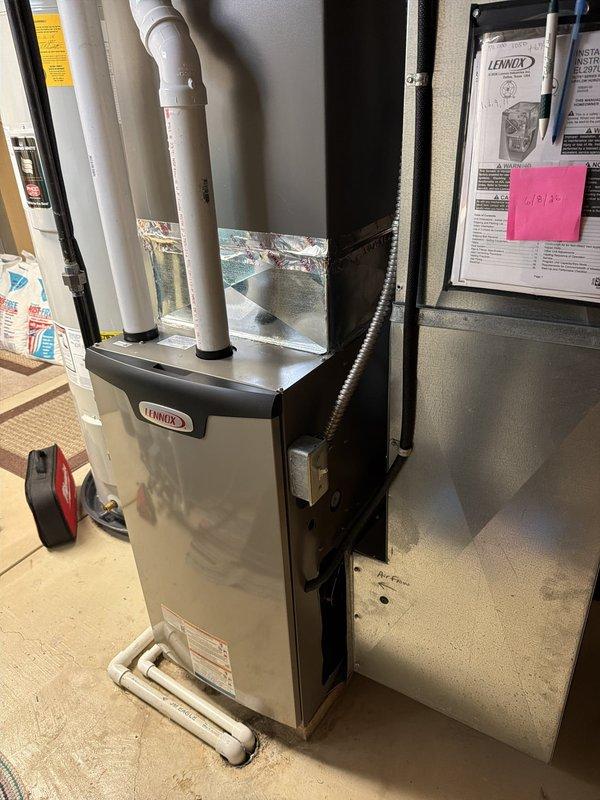 Completed installation of high-efficiency 97% AFUE Lennox furnace system in basement utility area. Unit installed with proper white PVC intake and exhaust venting routed through ceiling, all connections secured and tested for proper operation.