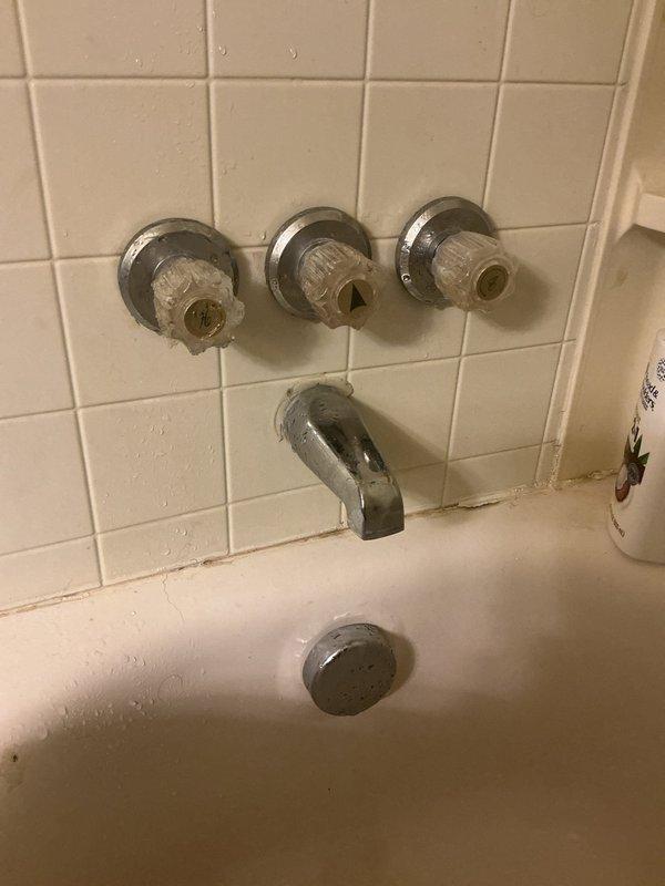 Replaced worn gaskets in the tub diverter valve assembly. Accessed the valve mechanism through the wall cavity behind the three-handle tub and shower fixture, removed the existing deteriorated gaskets, and installed new replacement gaskets to restore proper water flow control and eliminate leaks. Reassembled the valve components and verified proper operation of the diverter function.
