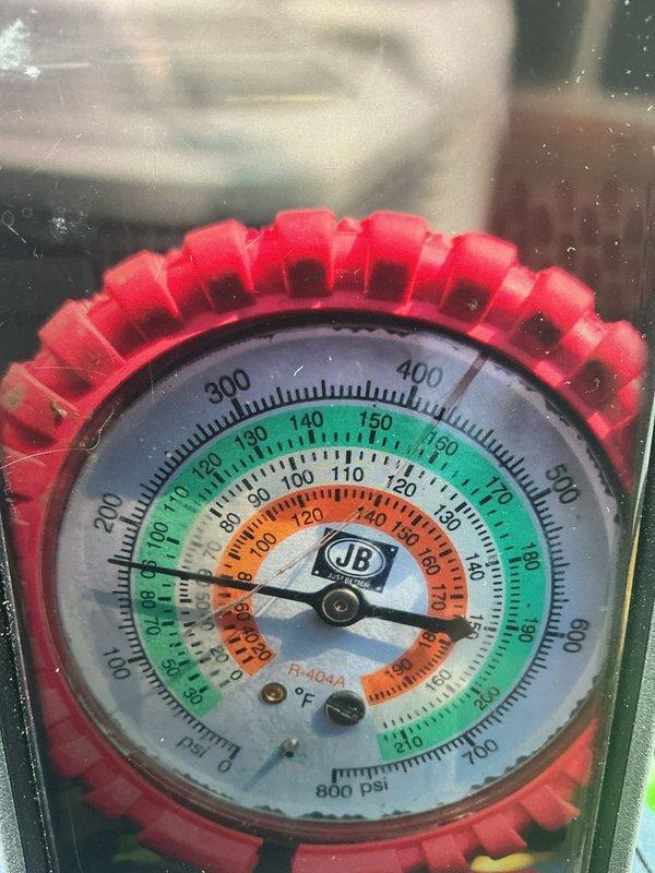 Responded to service call for 9-year-old central air conditioning system reported as not cooling properly. Upon arrival, connected manifold gauges to measure refrigerant pressures and diagnose system performance. Performed pressure testing on both high and low side lines to assess refrigerant charge levels and identify potential issues affecting cooling capacity. Gauges indicated abnormal pressure readings consistent with low refrigerant charge. Inspected condenser unit exterior components including coil fins and cabinet assembly. Documented system conditions with diagnostic photos showing gauge readings and equipment status for service records and customer reference.