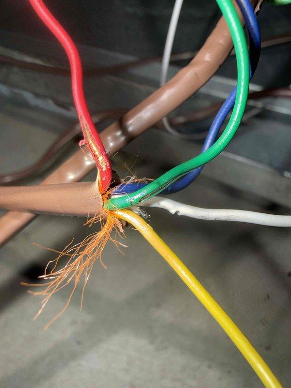 Responded to return service call for recurring thermostat and furnace communication failure on 10-year-old Lennox system. Upon inspection, discovered severely damaged low-voltage control wiring with burned and melted insulation, exposed copper conductors, and heat damage at wire junction point. Thermostat displayed Alert Code 105 indicating wiring issue and service urgent notification. Documented extensive wire damage affecting multiple colored control wires (red, green, blue, yellow, white, tan) at central connection point, which was causing communication breakdown between thermostat and HVAC equipment. Recommended immediate wiring repair or replacement to restore proper system communication and prevent potential safety hazard from damaged electrical connections.