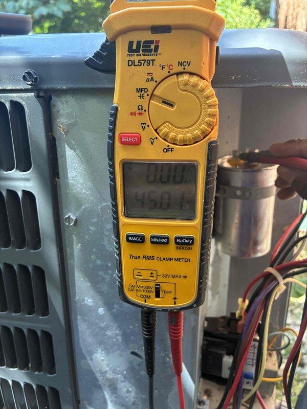 Performed routine maintenance on 6-year-old air conditioning system. Inspected evaporator coil and found significant accumulation of dirt, dust, and debris throughout the fin assembly, with heavy buildup particularly concentrated in upper sections that was restricting airflow. Conducted electrical diagnostics using clamp meter to verify system amperage and performance parameters at outdoor condensing unit. Measured capacitor values and confirmed proper electrical operation of compressor and fan motor circuits.
