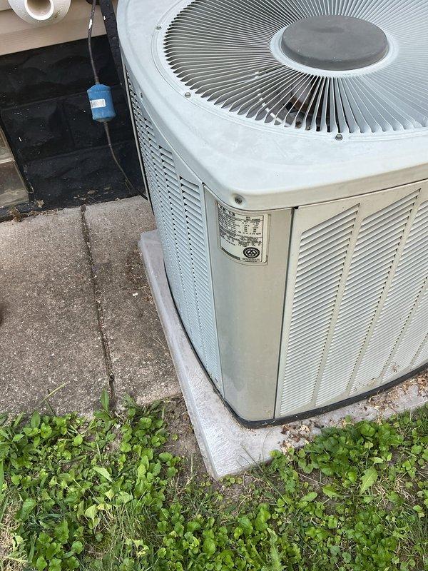 Responded to service call for 20-year-old air conditioning system with inadequate cooling performance and suspected refrigerant leak. Upon arrival, performed visual inspection of outdoor condenser unit and documented equipment condition. Unit showed signs of age-appropriate wear with vegetation growth around base and weathered concrete pad. Verified electrical connections and conduit routing to disconnect box. Assessed overall system operation and identified need for further diagnostic testing to determine refrigerant levels and locate potential leak points in aging system.
