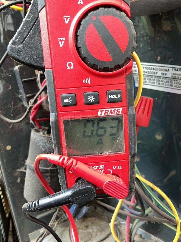 Performed maintenance visit on 12-year-old air conditioning system. Upon inspection, discovered evaporator coil completely frozen with heavy ice buildup throughout the serpentine coil assembly. Conducted electrical diagnostics using clamp meter, recording amperage draw of 7.53 amps at the system components. Documented frost accumulation on coil and refrigerant lines with photographic evidence for service records.