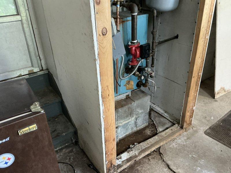 Responded to no-heat call on residential boiler system. Upon inspection, found heat exchanger heavily plugged with soot accumulation and identified active leak in unit. Boiler appears to be original equipment from 1970-1980 era. Baseboard heating system operates at 120°F. Documented existing conditions with photographs showing blue-painted boiler unit with associated piping, expansion tank, and circulator pump in basement installation. Provided estimate exceeding $1800 for complete system replacement with new boiler and associated components. Customer to confirm decision on proceeding with replacement versus repair options.