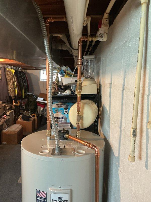 Replaced 40-gallon electric water heater in basement utility area. Unit was installed with proper copper piping connections, including sediment trap and pressure relief valve, and positioned on existing platform over carpeted surface. All plumbing connections were secured with appropriate fittings, and system was tested for proper operation upon completion.