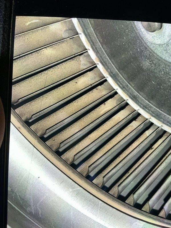 Completed comprehensive tune-up on 14-year-old air conditioning system. Inspected evaporator coil assembly and copper refrigerant lines, noting normal condensation present on suction line indicating proper system operation. Observed moderate dust accumulation on blower wheel fins; cleaned and verified proper airflow. All components operating within normal parameters for unit age.