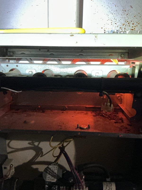 # HVAC Service Completed

Responded to service call for 20-year-old Trane XL90 air conditioning system reported as not working. Upon arrival, performed diagnostic inspection of both indoor and outdoor units. 

Interior furnace/air handler inspection revealed significant accumulation of dust and debris on evaporator coil assembly and drain pan, with visible deterioration of components. Heating elements showed signs of age-related wear. Electrical connections and wiring at indoor unit appeared intact but showed environmental exposure.

Outdoor condensing unit examination revealed aged capacitor with weathered wiring connections secured with zip ties. Contactor relay showed operational wear consistent with 20-year service life. Mounting base exhibited severe deterioration with rust staining and accumulated organic debris. Equipment showed extensive exposure to outdoor elements with vegetation encroachment near unit.

Documented current condition of both indoor and outdoor components throu