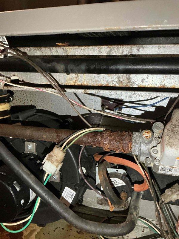 # HVAC Repair - Central Air Conditioner Ice Build-Up Resolution

Responded to service call for 15-year-old central air conditioning system experiencing ice accumulation during extended operation cycles. Upon arrival, contacted customer while en route as requested.

## Inspection and Diagnosis

Conducted comprehensive system evaluation to identify root cause of ice formation on evaporator coil. Accessed air handler unit and inspected internal components including blower motor assembly, evaporator coil section, and refrigerant lines. Documented existing conditions with photographic evidence showing:

- Corroded refrigerant line connections and mounting brackets with significant rust accumulation
- Aged insulation material on refrigerant lines showing signs of deterioration
- Blower motor assembly and housing in operational area
- 20x25x1 air filtration system configuration
- Overall equipment condition consistent with 15-year service life

Identified restricted airflow across evaporator 