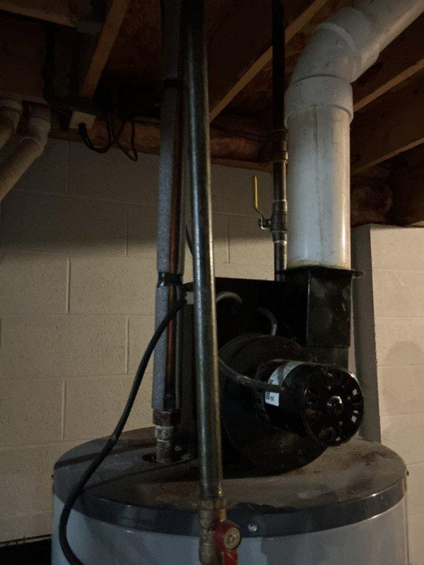 Conducted a comprehensive assessment of an existing Powerflex tanked water heater installation in a basement utility room to provide replacement estimate. The unit, of unknown age but at least 8+ years old, features standard copper supply line connections, PVC venting system, and power vent blower assembly mounted on top of the tank. Documented current installation configuration including electrical panel proximity, galvanized ductwork routing, existing plumbing connections, and overall system condition through detailed photographic documentation to support replacement recommendations.