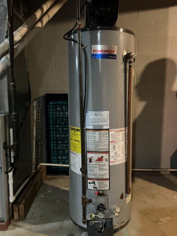 Conducted a comprehensive assessment of an existing Powerflex tanked water heater installation in a basement utility room to provide replacement estimate. The unit, of unknown age but at least 8+ years old, features standard copper supply line connections, PVC venting system, and power vent blower assembly mounted on top of the tank. Documented current installation configuration including electrical panel proximity, galvanized ductwork routing, existing plumbing connections, and overall system condition through detailed photographic documentation to support replacement recommendations.