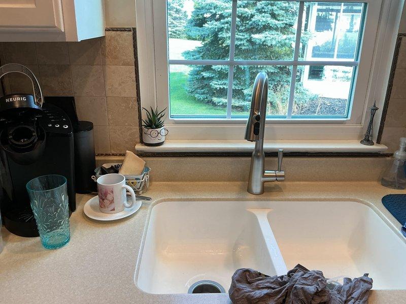 Installed customer-provided stainless steel pull-down faucet at kitchen double-basin undermount sink. Connected supply lines to existing plumbing beneath sink, verified proper water flow and drainage, and tested for leaks to ensure proper operation.