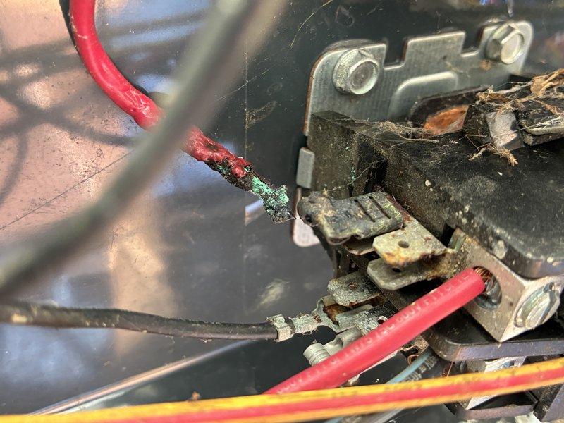 Responded to no cooling complaint on 15-year-old residential air conditioning system. Upon arrival, performed diagnostic inspection of outdoor condensing unit. Visual examination revealed severely corroded electrical connections at the contactor assembly, with heavy green copper oxidation and white crystalline deposits on wire terminals indicating prolonged moisture exposure. The deteriorated wiring and terminal connections were preventing proper electrical flow to the compressor and fan motor. Unit exterior showed significant weathering consistent with age, and heat exchanger coils displayed discoloration from years of outdoor exposure. Documented extensive corrosion damage with photographs for customer records. Advised customer that the electrical component failure due to corrosion was the root cause of system malfunction and provided recommendations for necessary repairs to restore cooling operation.