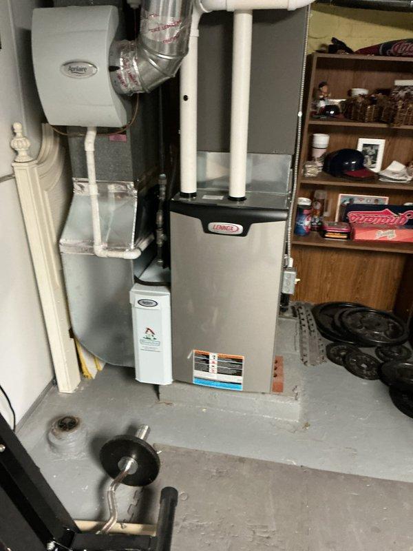 Completed scheduled air conditioning maintenance visit for MVP customer with 7-year-old system. Performed comprehensive inspection of Lennox HVAC equipment including furnace unit, Aprilaire humidifier, air filtration system, ductwork connections, and control components. Documented equipment condition with photographs showing proper installation of PVC piping, copper tubing, flexible ductwork, and blower motor components in basement mechanical room.