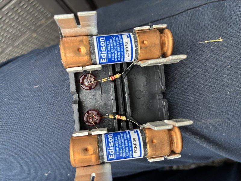 # HVAC Service Report

Responded to service call for excessive noise complaint on 3-year-old air conditioning system. Performed comprehensive diagnostic inspection of outdoor condensing unit and electrical control systems. Removed and examined control panel housing, inspecting all low-voltage control wiring, circuit boards, transformers, and electrical connections for loose components or mounting issues that could cause vibration noise.

Inspected dual-run capacitor assembly with Edison fuses for proper mounting and secure connections, as loose capacitors are a common source of humming or buzzing sounds. Verified all wire nuts, terminal connections, and circuit board mounting screws were properly tightened. Checked compressor mounting grommets and fan motor mounting hardware for wear or deterioration that could transmit excessive vibration to the unit cabinet. Assessed fan blade balance and clearance. Evaluated overall unit installation for proper pad leveling and secure mounting that 