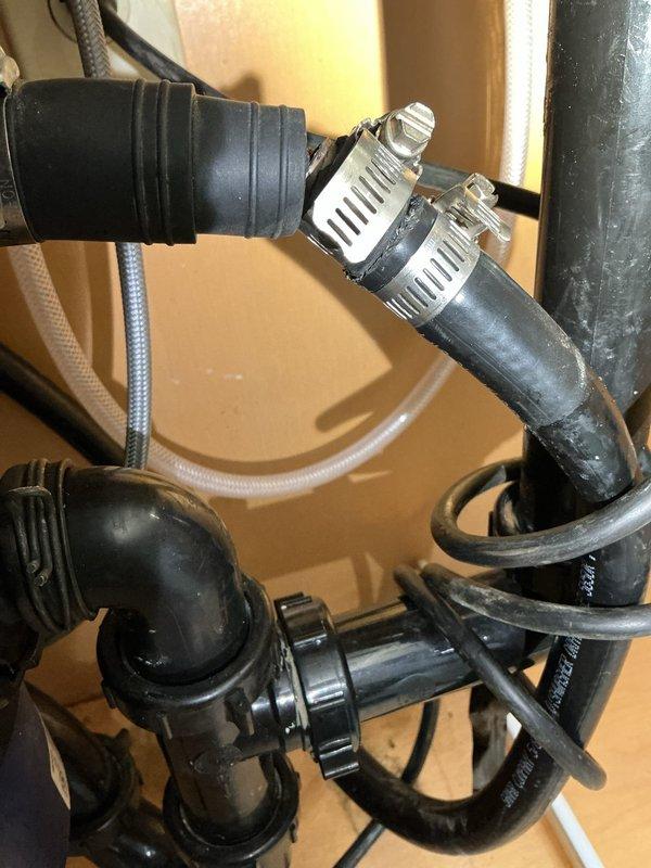 Responded to callback for leaking sink and garbage disposal connections following previous service visit. Upon inspection, identified active leaks at sink drain assembly and dishwasher discharge line connections. Removed and reinstalled garbage disposal with new mounting assembly and drain connections. Replaced deteriorated hose clamps and secured all drain hoses with stainless steel worm gear clamps. Reconnected dishwasher discharge line to disposal inlet with proper positioning to prevent backflow. Tested all connections by running water through sink basin and operating dishwasher through full drain cycle. Verified no leaks present at sink flange, disposal mounting ring, dishwasher connection, or waste line connections. All plumbing connections secure and functioning properly upon completion.