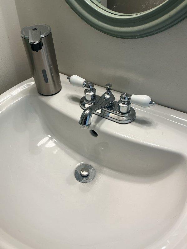 Replaced existing bathroom sink faucet with customer-provided chrome center-mount faucet featuring dual porcelain handles. Installed two new braided flexible supply lines to connect faucet to water supply. Replaced aging shut-off valves under sink with new chrome-plated angle stop valves to ensure proper water control and prevent future leaks. Tested all connections for leaks, verified hot and cold water flow, and confirmed proper operation of both handles and spout function.