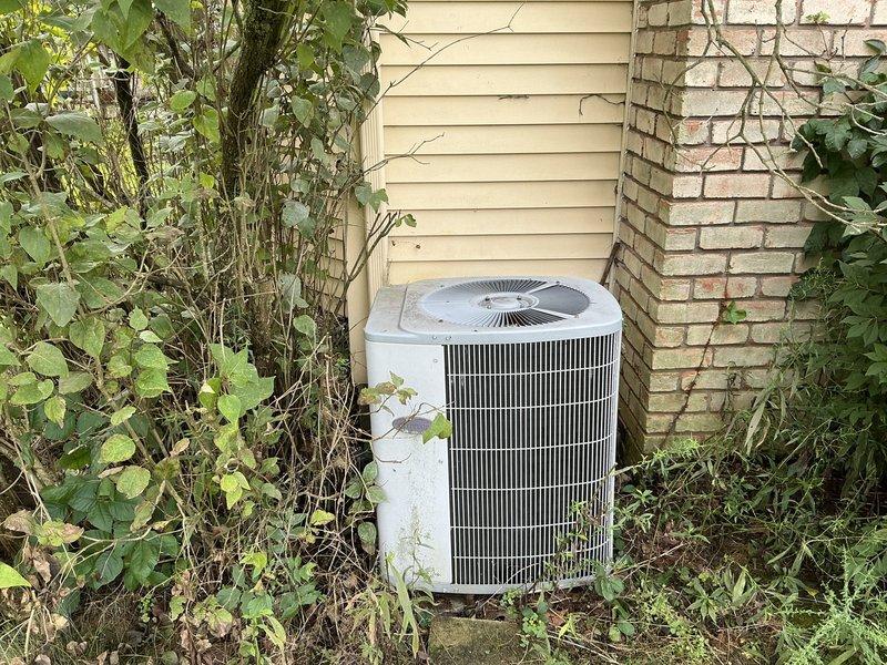 Provided estimate for replacement of 24-year-old R22 air conditioning system experiencing no cooling condition. Assessed existing outdoor condensing unit showing significant age and wear, surrounded by overgrown vegetation requiring clearance. Quoted repair options versus full system replacement, with recommendation for new equipment due to obsolete refrigerant type, age of system, and cost-effectiveness of replacement over continued repairs to aging components.