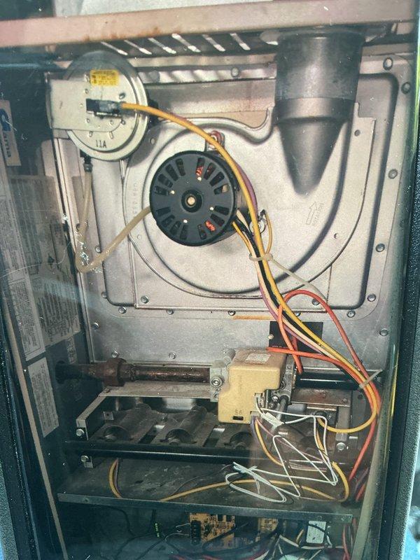 Completed MVP Cooling Visit recurring maintenance service on residential HVAC system. Performed comprehensive inspection of blower motor assembly, noting moderate rust and corrosion on motor plate consistent with unit age and operational history. Verified electrical connections including motor wiring harness with red, yellow, black, and orange conductors all secure and properly terminated. Inspected blower wheel and housing for debris accumulation and operational clearances. Examined capacitor mounting and electrical connections, confirming proper installation and function. Evaluated control board, relay components, and transformer wiring integrity. All mechanical fasteners, mounting brackets, and structural supports verified secure. System operational and functioning within normal parameters at time of service completion.