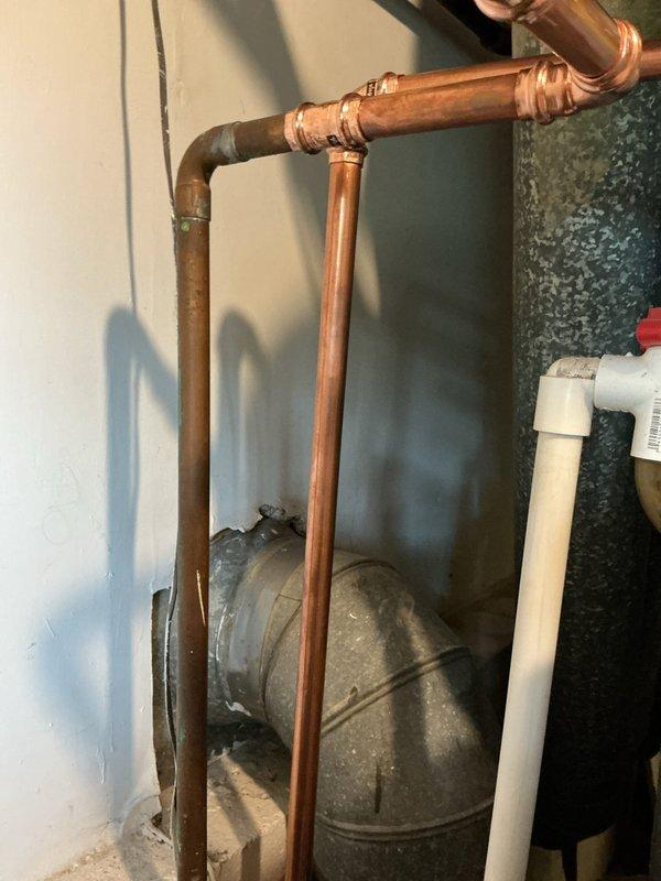 Installed a new 40-gallon Bradford White water heater with 6-year manufacturer warranty, including new ball valve, thermal expansion tank, and 1/4" shut-off valve for humidifier connection. Removed existing water heater and cut out old main water gate valve at meter location. Rebuilt main water line from meter with secondary ball valve installed after meter, installed new tee fitting for house water distribution, and ran complete copper piping to new water heater with proper fittings and connections. Water utility shut off supply at street curb to facilitate main line replacement work. All copper joints soldered, system pressure tested, and water heater commissioned for operation.