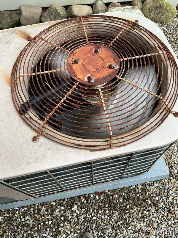 Completed MVP cooling maintenance visit on residential heat pump unit of unknown age. Performed standard preventive maintenance inspection of outdoor condenser unit, which exhibited significant rust and corrosion on top-mounted fan guard assembly and center hub components due to prolonged weather exposure. Unit remains operational with all major components functioning, though exterior metal surfaces show advanced oxidation typical of aged outdoor HVAC equipment.