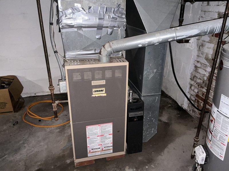 Conducted comprehensive assessment of existing HVAC system in basement mechanical room for complete furnace and air conditioning replacement estimate. Evaluated current Luxaire furnace unit and associated air handler, documented existing ductwork configuration including flexible and rigid metal ducts, and assessed utility room infrastructure including water heater clearances and available space for new equipment installation. Photographed all existing equipment, connections, and mechanical room layout to provide accurate replacement specifications for bundled furnace and AC system upgrade per promotional offer inquiry.