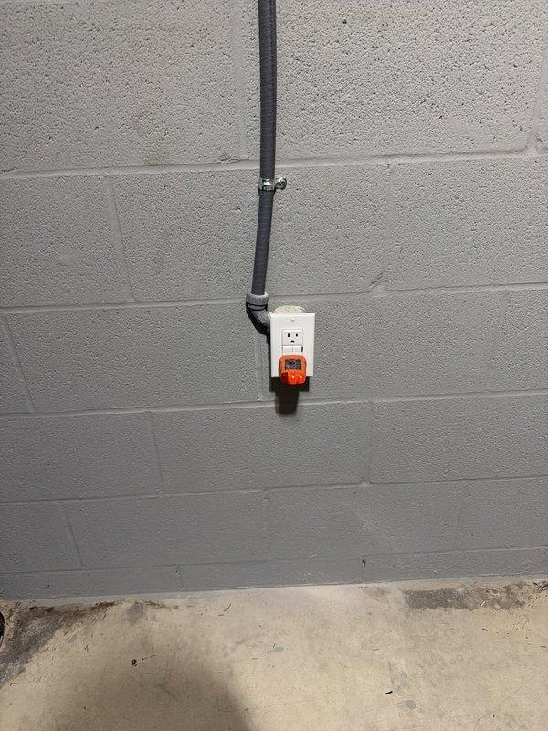 Installed three new electrical outlets in unfinished basement area using surface-mounted conduit and outlet boxes on concrete block walls. Ran black EMT conduit vertically along painted CMU wall with proper mounting straps, installed standard duplex receptacles and GFCI protection where required per code. All materials were available from truck stock, and installation was completed through exposed floor joist space with appropriate wire routing and support.