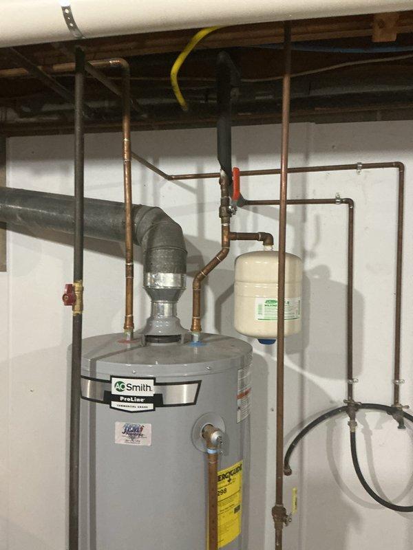 Responded to service call for A.O. Smith ProLine tanked water heater not producing adequate hot water. Upon arrival, performed diagnostic inspection of unit and associated plumbing components. Evaluated water heater operation, checked temperature settings, and inspected copper supply lines, expansion tank, shut-off valves, and gas line connections. Documented existing installation configuration including properly mounted expansion tank, isolation valves, and pressure relief components. System assessment completed and findings documented with photographic evidence of unit condition and plumbing infrastructure in basement utility room.