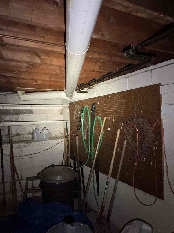 Conducted electrical estimate for standby generator installation at residential property. Evaluated basement utility area and exterior installation location, documenting existing electrical infrastructure and available space for equipment placement. Assessed structural conditions including ceiling joists, wall mounting options, and access routes for future generator installation. Customer inquired about technician experience and company tenure during consultation. Photographed proposed installation areas including interior utility space with tool storage and exterior window location adjacent to lawn area for equipment positioning reference.