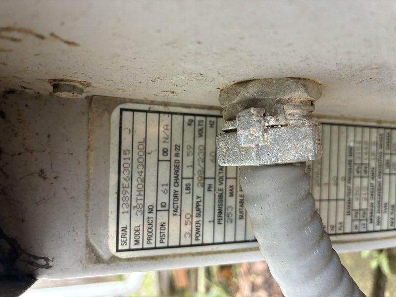 # No Cool Service Call - 20-Year-Old Carrier AC Unit

Responded to a no cooling complaint on an approximately 20-year-old Carrier air conditioning system. Upon arrival, performed visual inspection of the outdoor condensing unit. Found the condenser coils heavily soiled with accumulated dirt, debris, and organic matter, significantly restricting airflow through the coil surfaces. The unit's cylindrical protective cage showed substantial weathering and the surrounding area contained leaves, mulch, and vegetation debris contributing to reduced system efficiency.

Documented equipment condition through photographs showing deteriorated component surfaces, staining on the unit's base panel, and environmental wear consistent with two decades of outdoor exposure. The condenser's placement on bare ground with inadequate clearance from surrounding vegetation and debris contributed to accelerated dirt accumulation on critical heat exchange surfaces.

Given the system's age at 20 years and the ext