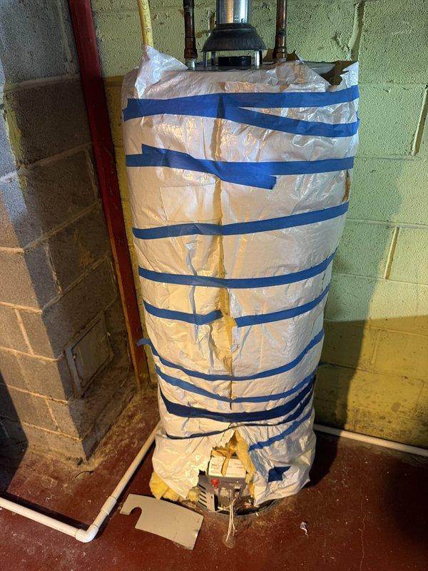 Responded to no hot water call at residential property. Upon arrival, inspected tanked water heater unit located in basement utility area. Assessed pilot light assembly and burner controls as reported by customer. Water heater appeared to be standard gas-fired unit with copper supply lines, pressure relief valve, and gas line connection. Unit showed existing insulation wrap with securing straps. Performed diagnostic evaluation of heating system components including gas valve, thermocouple, and pilot assembly. Verified proper gas supply via flexible gas line connection. Inspected all plumbing connections at top of unit including hot water outlet and cold water inlet with shut-off valve. Examined floor-mounted control components and verified proper installation of all safety devices. Restored hot water service to residence.
