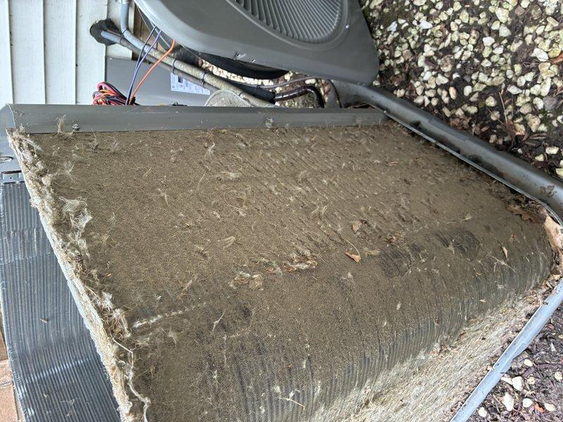 Completed MVP cooling maintenance visit on residential HVAC system. Inspected outdoor condenser unit and indoor air handler components, documenting heavily soiled air filter with significant accumulation of dust and debris requiring replacement. Examined capacitor, blower motor assembly, and electrical connections; noted rust staining on motor housing consistent with normal environmental exposure over time. All system components operational and electrical connections secure.