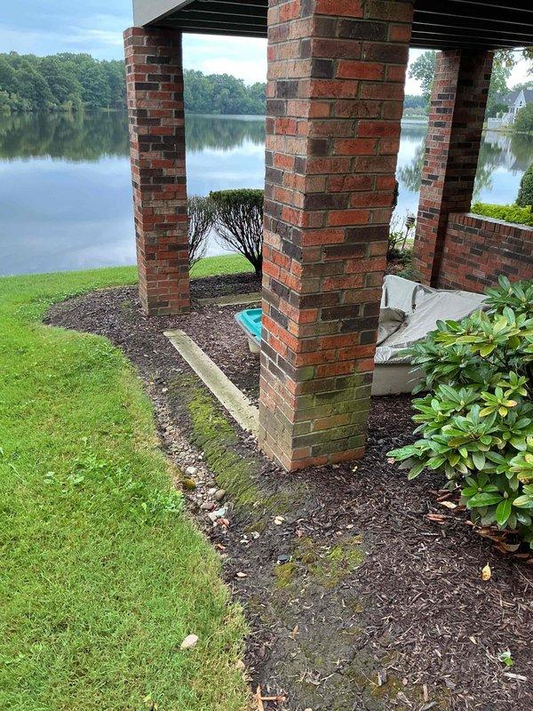 Conducted comprehensive site assessment for residential backup generator installation at waterfront property. Evaluated existing electrical infrastructure, including current meter enclosures and exterior utility connections on home's foundation wall. Documented optimal generator placement location near existing electrical service entry point, considering code compliance requirements for clearances from structure, utilities, and landscaping features. Photographed site conditions including brick column pergola structure, landscaped areas with mulch beds, and available routing paths for electrical conduit and gas connections. Assessed adequate space for generator pad installation while maintaining aesthetic integration with existing outdoor features and preserving water view. Documented all necessary measurements and existing utility locations to prepare detailed equipment and installation cost estimate for customer review.