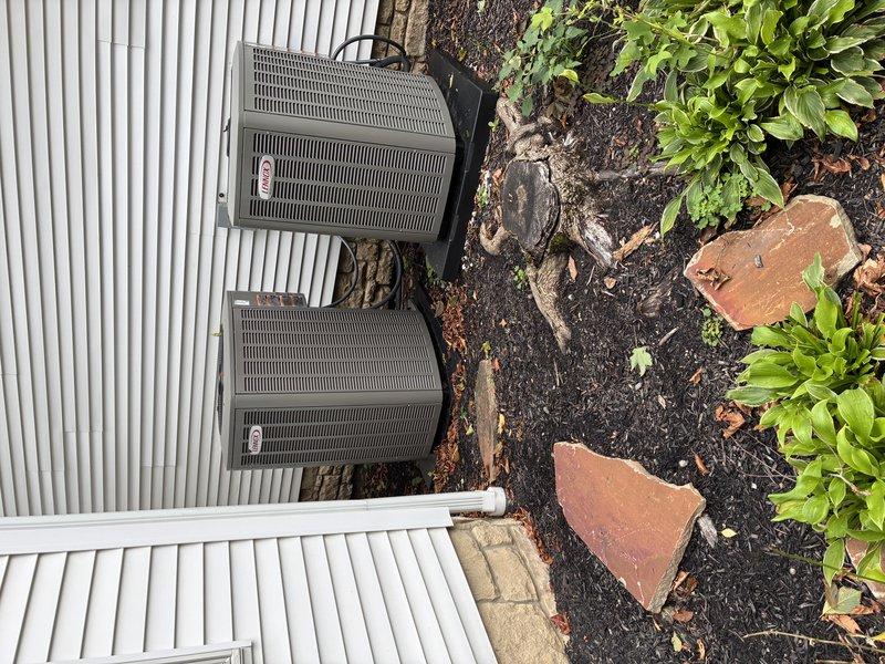 # HVAC Service Completed

Responded to callback regarding outdoor condensing unit stability concerns following initial installation. Performed thorough inspection of dual HVAC condenser installation against white corrugated metal siding. Examined unit mounting, pad integrity, and securing mechanisms. Verified refrigerant line connections, electrical conduit routing, and overall equipment positioning. Inspected concrete pad placement and levelness of both units. Confirmed proper clearances from building structure and landscaping elements. Documented installation condition with photographic evidence showing units, copper line sets, electrical connections, and surrounding area. Equipment found to be properly secured with no structural deficiencies or safety concerns identified. Units operating within normal parameters with appropriate weathering for outdoor installation timeframe.
